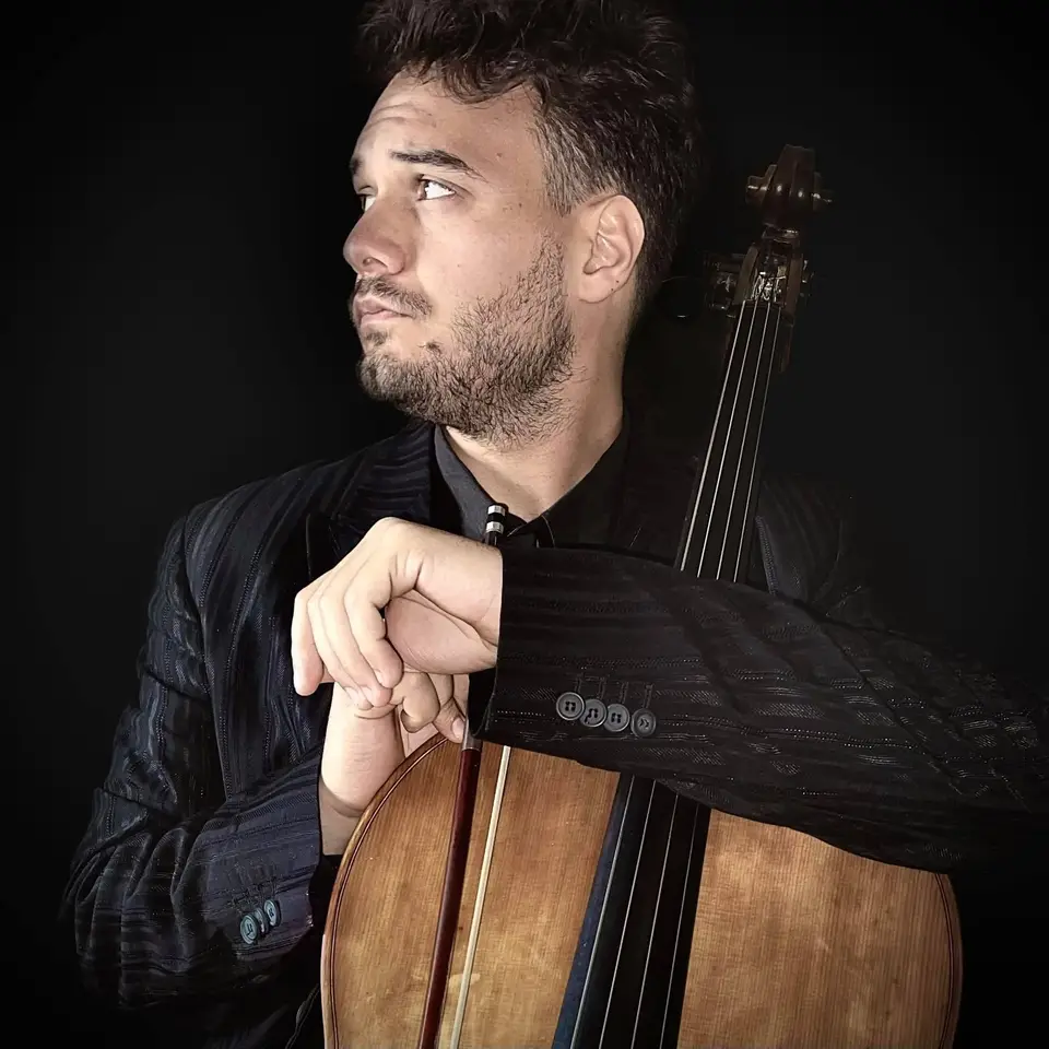 Angelo Federico in abito da concerto accanto al violoncello